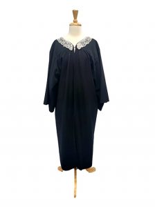 Image shows a mannequin wearing a black Judges robe with an attached lace collar, suitable for judge Judy or Ruth Bader Ginsburg